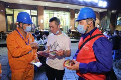 為各個(gè)攤位檢查用電安全情況、排查隱患、發(fā)放用電安全宣傳單